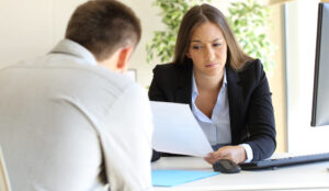 Woman frowning upon bad resume in a job interview